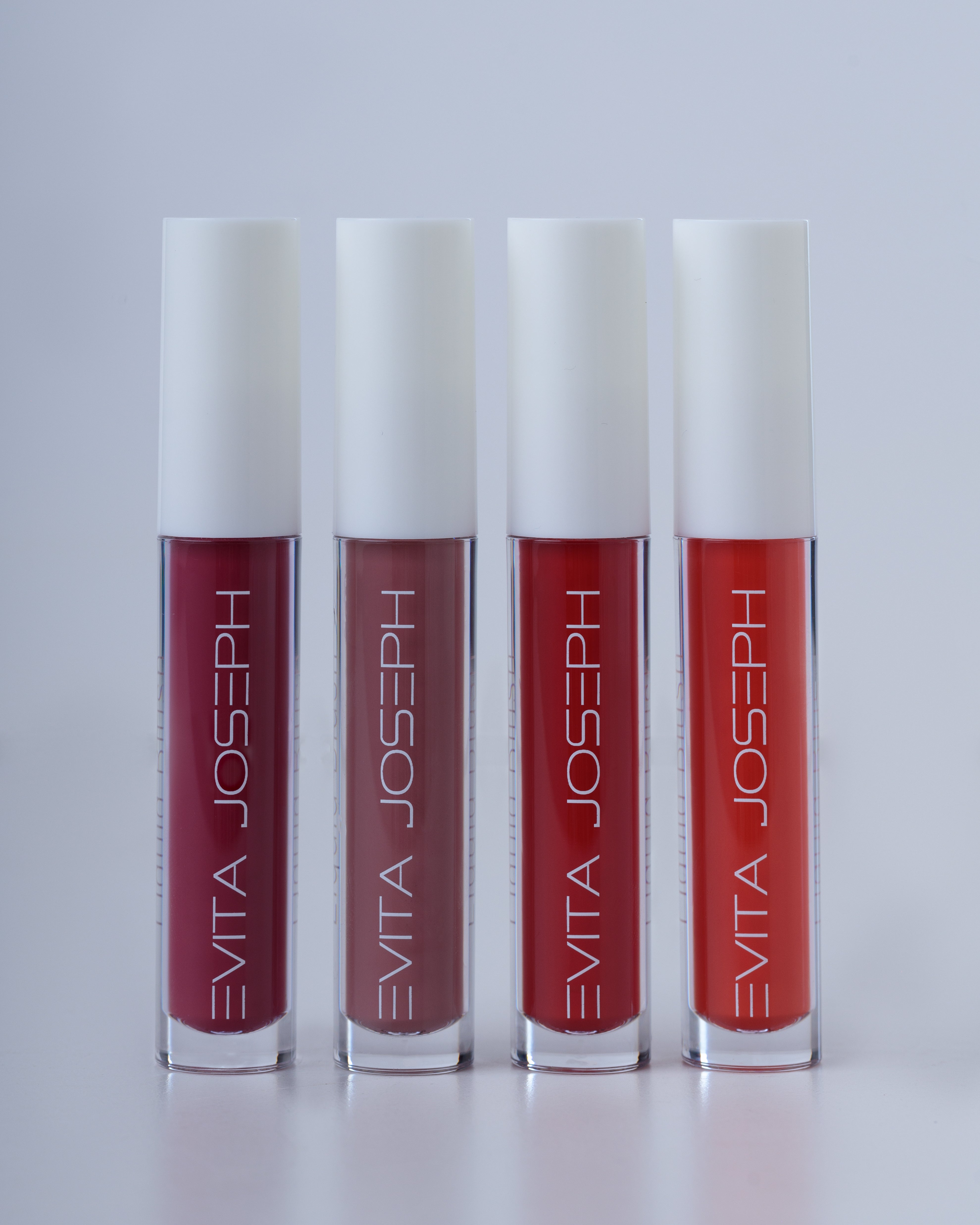Four liquid blush containers in a row with a gradient of colors from pink to red, labeled Evita Joseph.
